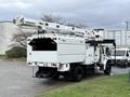 A 2015 Freightliner M2 bucket truck with an Altec aerial lift attached on the back, featuring a white body and a storage compartment