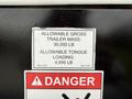 A black sign displaying weight limits for a trailer attached to a 2016 Peterbilt 348 indicating allowable gross trailer mass and allowable tongue loading
