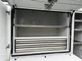 The image shows the interior of a cargo area with metal shelving and multiple sliding compartments in a 2024 RAM 5500 vehicle