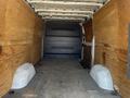 Interior view of a 2016 Mercedes-Benz Sprinter van showing bare wooden walls and a clear cargo space with a flat floor and curved wheel wells
