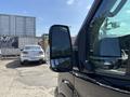 A 2025 Ford Transit T-350 with a focus on the driver's side mirror and part of the vehicle door visible in the foreground