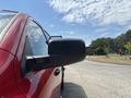 A red 2013 RAM 2500 truck with a side mirror prominently displayed in the foreground