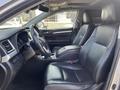 Interior view of a 2018 Toyota Highlander featuring black leather seats and a modern dashboard with controls and a steering wheel