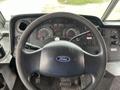 Interior view of a 2011 Ford Econoline dashboard featuring the steering wheel and various gauges and controls