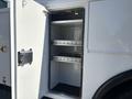 An open white cabinet with two metal shelves inside on a 2013 International 7500 vehicle
