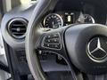 Close-up of the steering wheel and controls of a 2020 Mercedes-Benz Metris featuring a Mercedes logo and various buttons for navigation and settings
