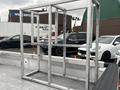A metal frame structure placed in the bed of a 2013 Ford F-150 surrounded by parked vehicles
