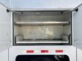 A 2006 International 4300 with an open cargo area featuring two metal shelves and a clean interior surface