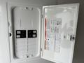 An open white electrical panel with multiple circuit breakers visible inside