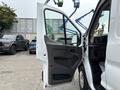 A 2020 Ford Transit 250 with the driver's side door open showcasing the interior features and driver's seat