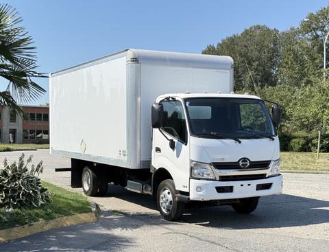 A white 2020 Hino 155 box truck with a cargo box and no visible markings parked on a drive