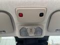 Overhead control panel with two buttons labeled SOS in red and ASSIST in black along with two circular speakers integrated into the ceiling of a vehicle