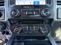Dashboard controls of a 2018 Ford F-150 featuring audio and climate control buttons along with a touchscreen display