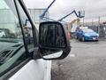 A 2019 Ford Transit Connect with a close-up view of its side mirror reflecting raindrops and the surrounding area