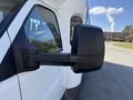 A close-up of the side mirror of a white 2017 Chevrolet Express van