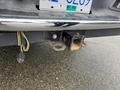 A hitch receiver attached to the rear of a 2006 Dodge Ram 2500 showing signs of rust and wear