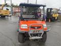 A red 2010 Kubota RTV 900 utility vehicle with a black roof and protective front guard