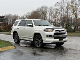 A white 2018 Toyota 4Runner is parked at an angle showcasing its front profile and sleek design with black accents on the hood and sporty wheels