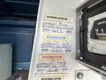 A 2006 Ford Econoline with multiple testing labels attached to the interior panel showcasing inspection dates and details