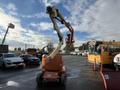 A 2012 JLG E400AJFN aerial lift with a raised platform and extended arm positioned upward