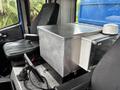 A 2017 Autocar Xpert featuring a metallic storage box on the passenger seat with a fan attached and a control panel in front of the seat
