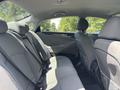 The interior of a 2014 Hyundai Sonata showcasing the back seat area with grey fabric upholstery and spacious seating arrangement
