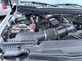 Close-up of the engine compartment of a 2023 Ford F-250 featuring the air intake system and battery components visible in detail