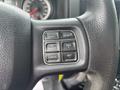 Close-up of the steering wheel controls of a 2016 RAM 1500 featuring buttons for gear selection and cruise control settings