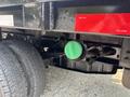 A green cap is attached to a black fluid reservoir on a 2009 Ford F-450 Super Duty vehicle's undercarriage showing part of the suspension and rear tires