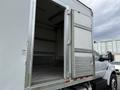 A 2019 Ford F-750 with an open cargo box revealing empty interior space and double doors that swing outward