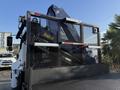 A 2015 Hino 358 towing truck with a large hydraulic crane attachment at the rear featuring a protective metal mesh and a textured flatbed surface