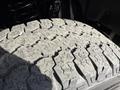 A close-up view of a rugged tire tread from a 2021 Ford F-250 SD showcasing distinct patterns and grooves designed for off-road traction