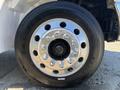 Close-up of a shiny chrome wheel with multiple bolt holes and a black tire labeled K2106 EX