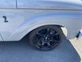 Close-up of the front wheel and fender of a 1962 Ford 2WHDR featuring a black alloy wheel and low-profile tire