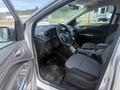Interior of a 2014 Ford Escape featuring grey seats a console with controls and a steering wheel visible from the driver's seat