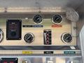 Control panel of a 1999 Freightliner FL80 featuring gauges lights and switches for various functions including discharge and tank fill operations