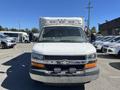 A 2013 Chevrolet Express van facing forward with a white exterior features a large windshield and two side mirrors