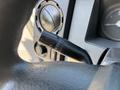 Close-up of the turn signal stalk and dashboard controls in a 2011 Ford F-550 cabin with various switches and gauges visible