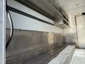 Interior view of a 2017 Freightliner MT45 with metallic diamond plate flooring and storage shelves along the walls