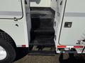 A 2008 International 7500 truck with a set of metal steps leading up to the entrance area adorned with a textured surface for grip