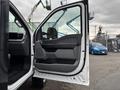 A 2023 Ford F-450 Super Duty with an open driver side door showcasing the interior door panel and controls