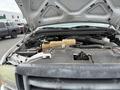 A 2004 Ford F-350 SD with its hood raised exposing the engine compartment featuring various mechanical components and fluid reservoirs