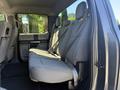 Interior of a 2018 Ford F-150 showing the back seat with two seat belts and a cloth texture on the seating surfaces