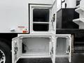 A 2020 International MV607 truck featuring an open storage compartment with two smaller doors below a larger main compartment