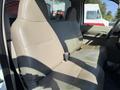 A 2008 Ford F-450 SD with a spacious front bench seat in beige fabric showing signs of wear and two seatbelts