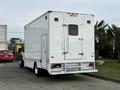 A white 2012 Ford F-550 service truck with a closed rear compartment and side access door