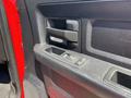 Close-up of the door handle and window control panel of a 2013 RAM 2500 showcasing a black textured surface and control buttons