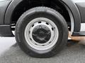 A close-up of a wheel on a 2022 Ford Transit showcasing a silver steel rim with central lug nuts and a black tire with treads
