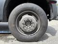 Close-up of a 2013 Ford F-550 tire with a gray rim showcasing a six-bolt pattern and prominent tire tread markings