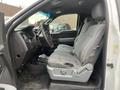 Interior view of a 2013 Ford F-150 showing the driver's side with gray fabric seats and a steering wheel